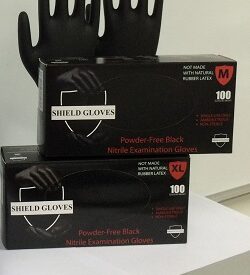 Two black gloves behind two stacked boxes of gloves.