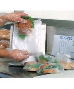 two hands holding plastic bag to show size with food behind the bag